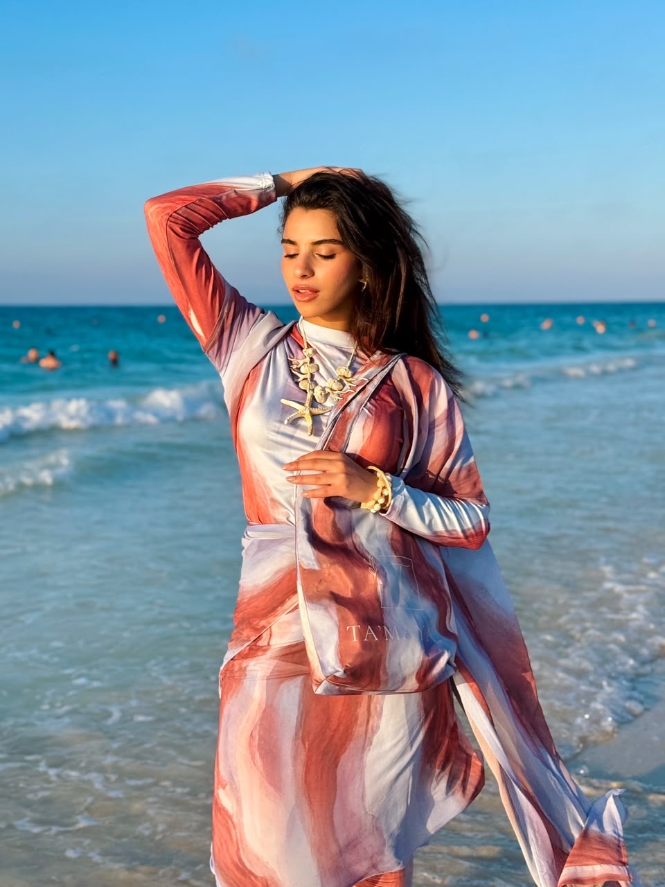Ta’mayaa stylish swimmers swimwear with long sleeve cover-up in red and white marble design on beach