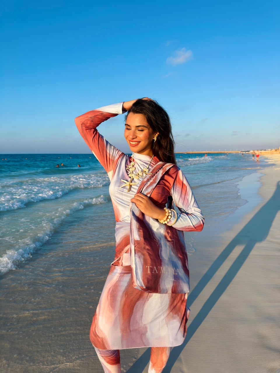 Ta’mayaa stylish swimmers swimwear with long sleeve top and matching skirt on beach by the ocean