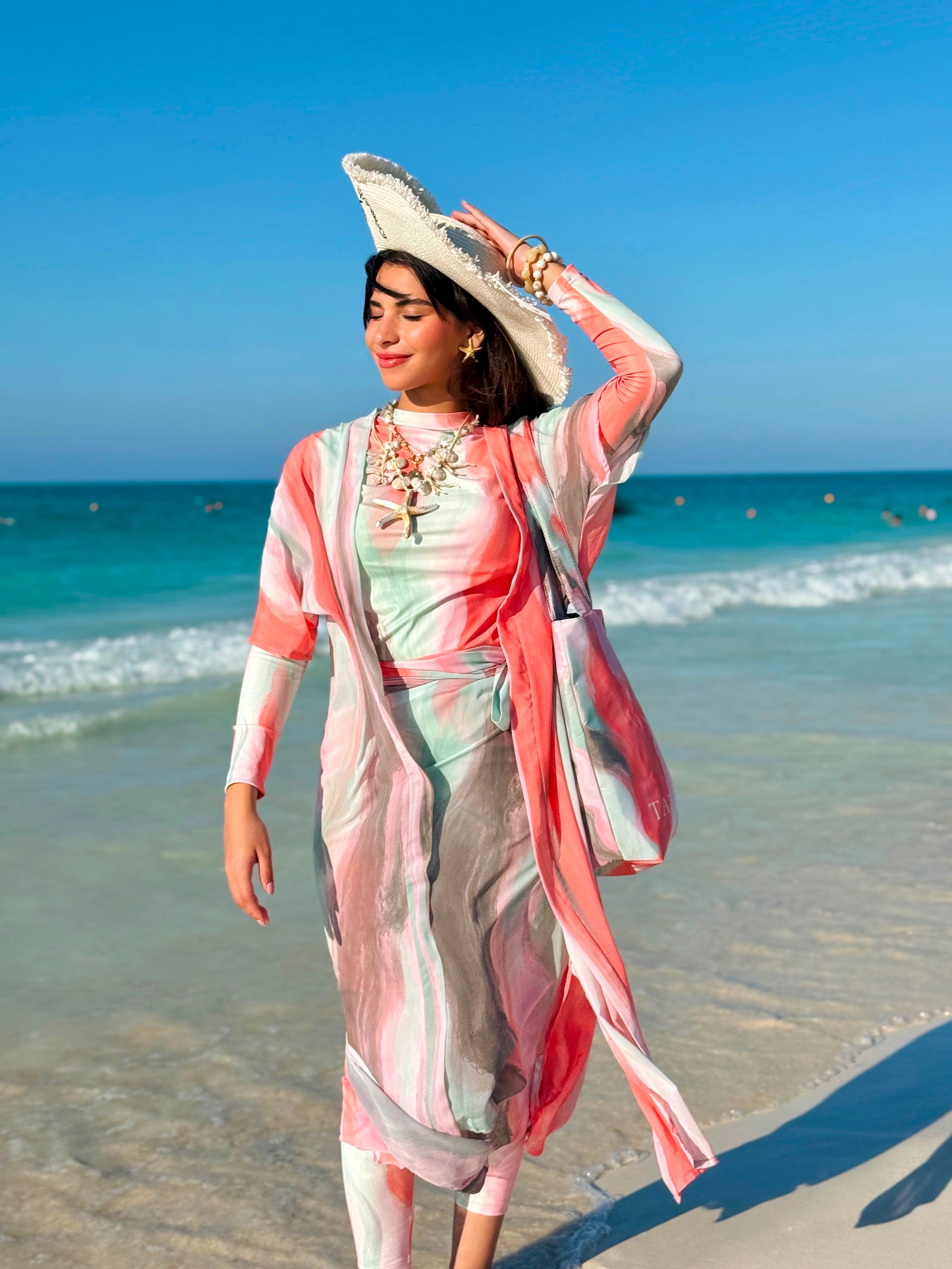 Ta’mayaa stylish swimmers swimwear with matching cover-up worn by woman on sunny beach